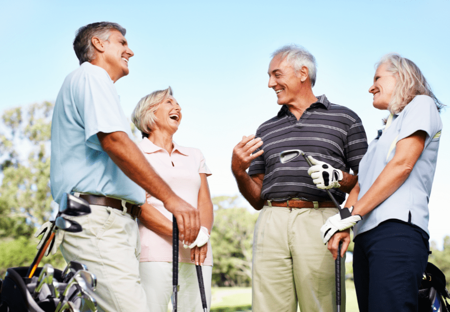 Two men and women of retirement age enjoying playing golf