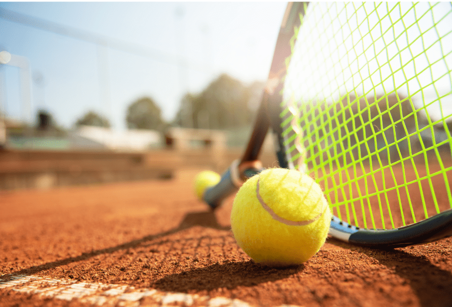 Yellow Tennis Ball in Front of a Tennis Racquet